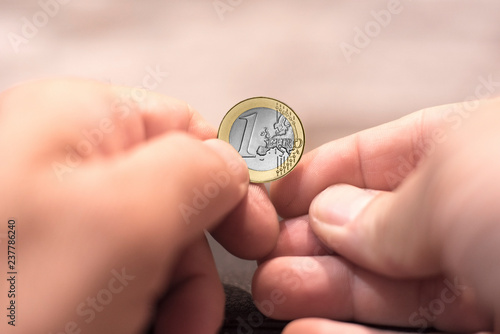 Close up capture of hands holding one euro coin