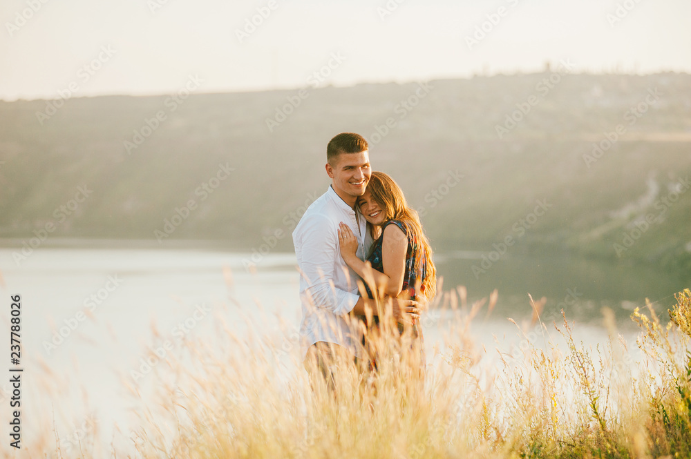 Cheerful romantic couple hugging in nature Cheerful romantic couple hugging in nature