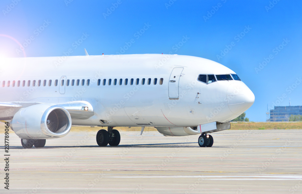 Nose of white aircraft with a chassis on airport runway