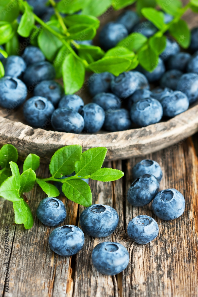 Blueberries with leaves on old wooden table Blueberries with leaves on old wooden table