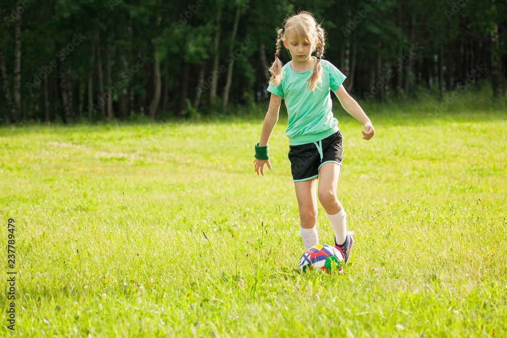 Girl playing soccer in the grass field Girl playing soccer in the grass field