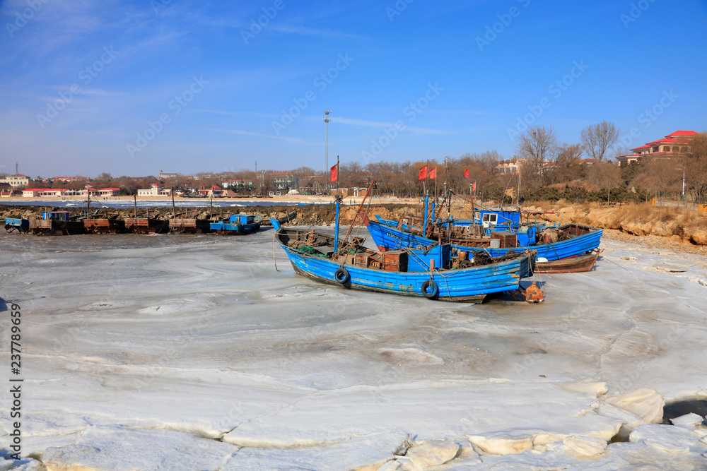 Wooden fishing boat on the shores of an icy bay