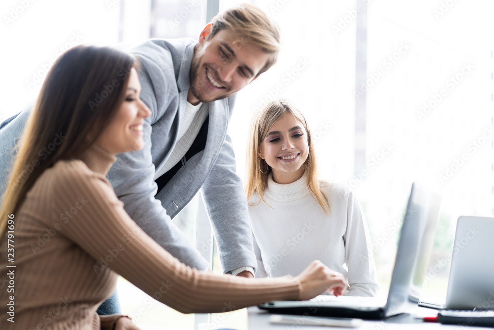 Working day. Group of young modern people in smart casual wear discussing business while working in the creative office. Working day. Group of young modern people in smart casual wear discussing business while working in the creative office.