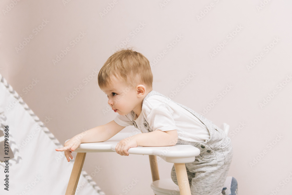 Cute baby sitting at the table in the form of a cloud in the nursery bright colors. Cute baby sitting at the table in the form of a cloud in the nursery bright colors.