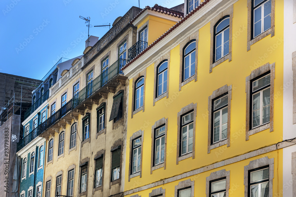 A traditional old building in Lisbon downtown with different colors in a blue sky day