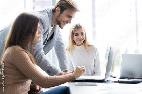 Sharing opinions. Group of young modern people in smart casual wear discussing business while working in the creative office.