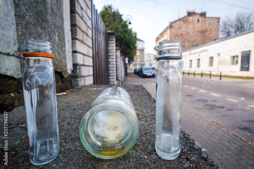 3 empty small alcohol bottles on the empty street in Warsaw, Poland