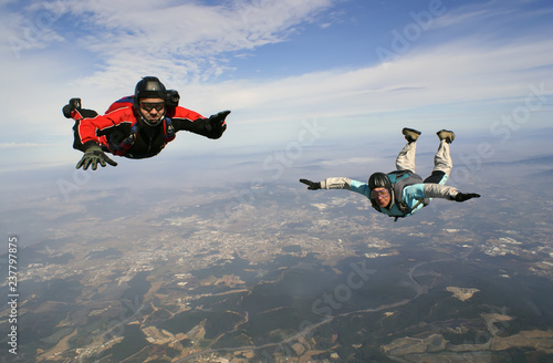 A young and old man jumping from parachute together.