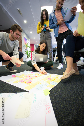 Startup business people in modern office. Group of young business people are working together with laptop. Freelancers sitting on the floor. tech startup, tech team.