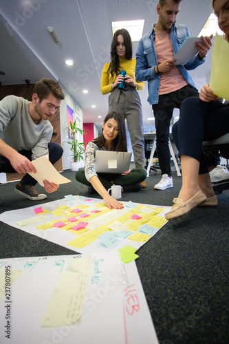Startup business people in modern office. Group of young business people are working together with laptop. Freelancers sitting on the floor. tech startup, tech team.