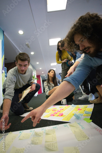 Startup business people in modern office. Group of young business people are working together with laptop. Freelancers sitting on the floor. tech startup, tech team.