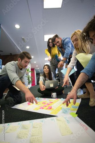 Startup business people in modern office. Group of young business people are working together with laptop. Freelancers sitting on the floor. tech startup, tech team.
