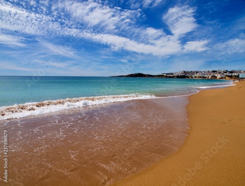 Paradies strand mit feinem roten Sand am tükis farbigen Meer mit Wolken am blauen Himmel