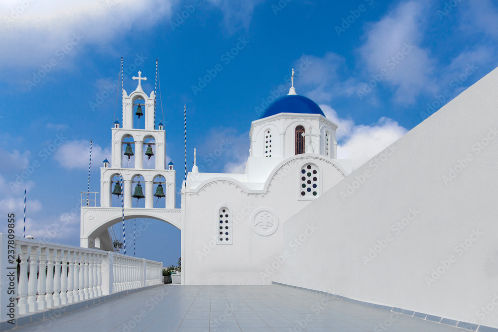 Very beautiful Orthodox church in the city of Karterados on the island of Santorini. Typical white church on Santorini. Photo of a greek church in Santorini and the blue sky