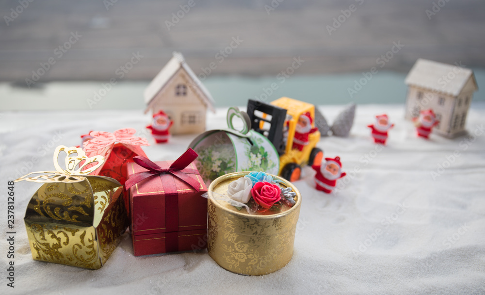 Miniature Gift Box by Forklift Machine on snow ,Determined Image for Christmas Holiday and Happy New Year Gift Celebration concept. Miniature Gift Box by Forklift Machine on snow ,Determined Image for Christmas Holiday and Happy New Year Gift Celebration concept.