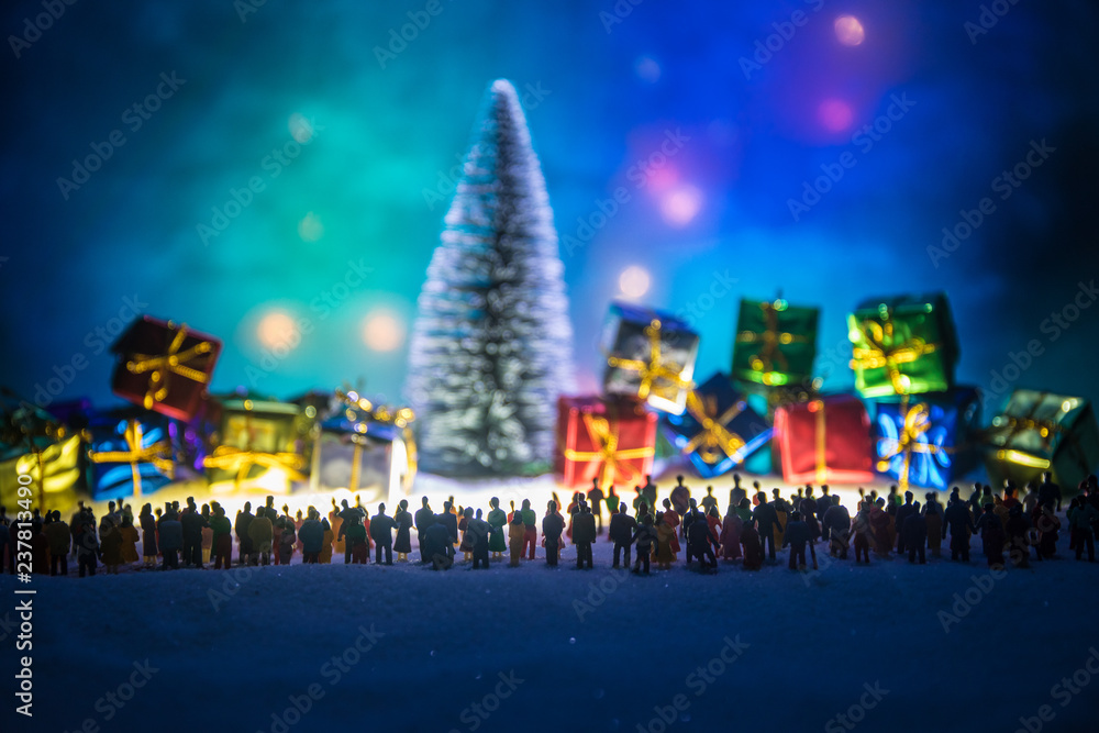 New year or Christmas holiday shopping concept. Store promotions. Silhouette of a large crowd of people watching at a big shopping trolley with gifts. People on snow prepares to shopping.