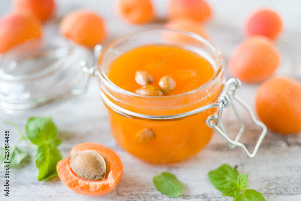jar with homemade apricot jam on a light wooden background jar with homemade apricot jam on a light wooden background