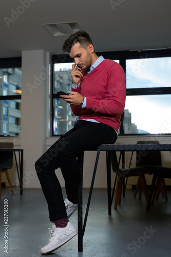 Man typing on the mobile phone in the office