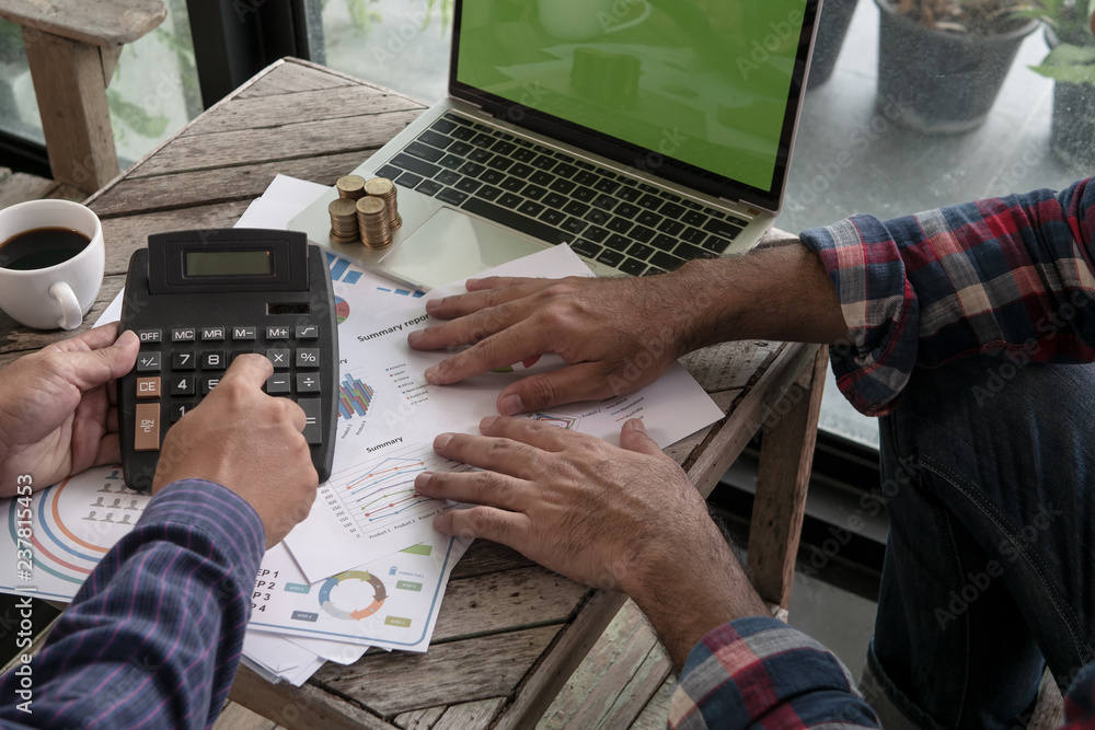 Fototapeta premium Business meeting at cafe. Hand of Businessman working new startup project with laptop computer on wood table. Idea presentation, analyze plans...