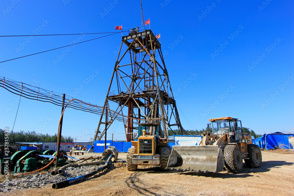 Drilling derrick and heavy duty truck in MaCheng iron mine, China Drilling derrick and heavy duty truck in MaCheng iron mine, China