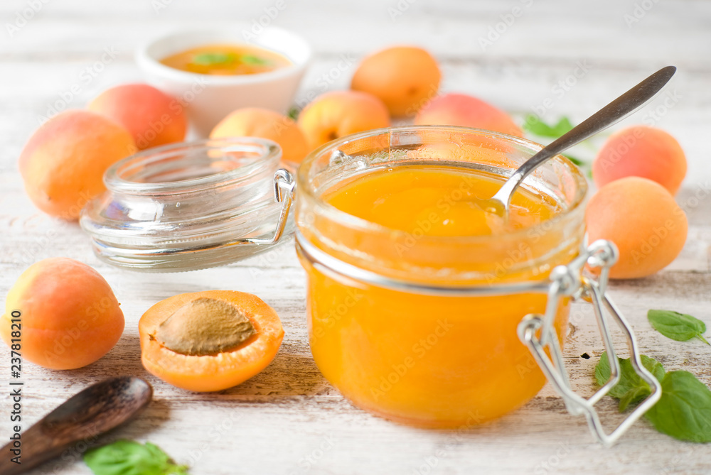 jar with homemade apricot jam on a light wooden background jar with homemade apricot jam on a light wooden background