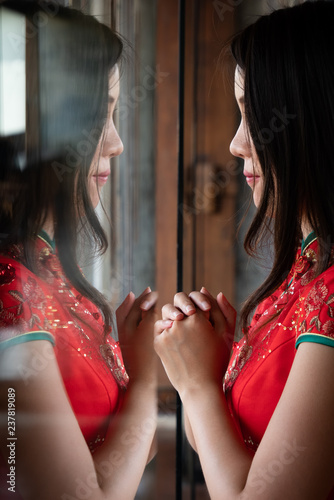 women in china dress reflax on mirror photo