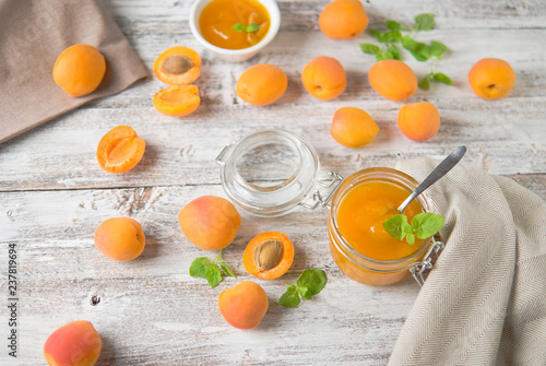 jar with homemade apricot jam on a light wooden background