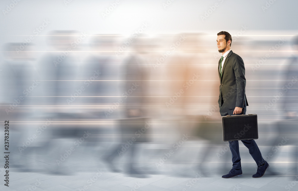 Young businessman with briefcase hurry up on a crowded street with blurred people around
Young businessman with briefcase hurry up on a crowded street with blurred people around