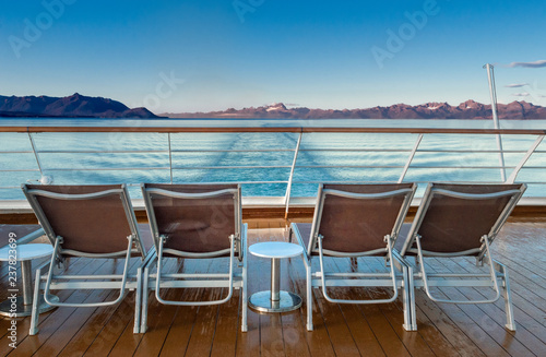 Row of empty plastic cruise ship deck lounge chairs early morning, Alaska, USA.