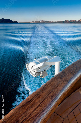 Ship's wake and auxilliary light in the cool clear air of dawn, Alaska, USA. photo