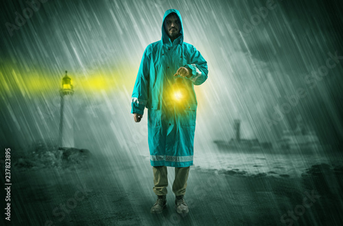 Man at the coast coming in raincoat with glowing lantern concept 