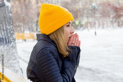Принти на полотні beautiful young woman warming her hands on the street in winter
