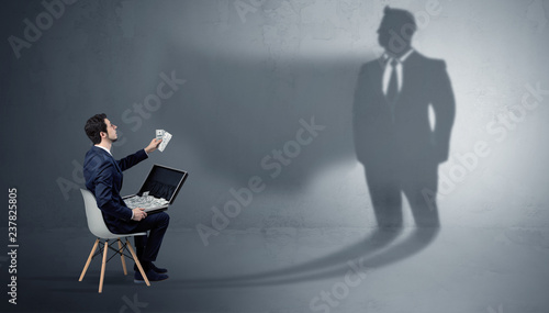 фотографія Humble businessman staying and offering stuffs to a huge businessman shadow