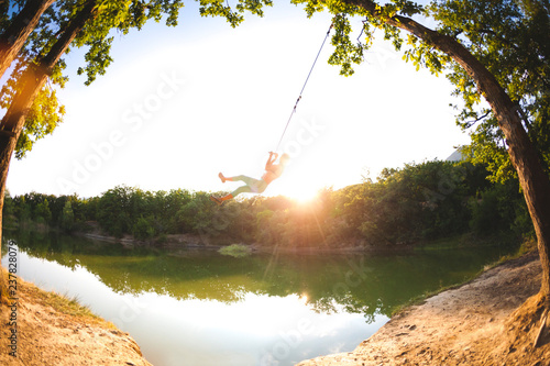 A woman is riding a swing.