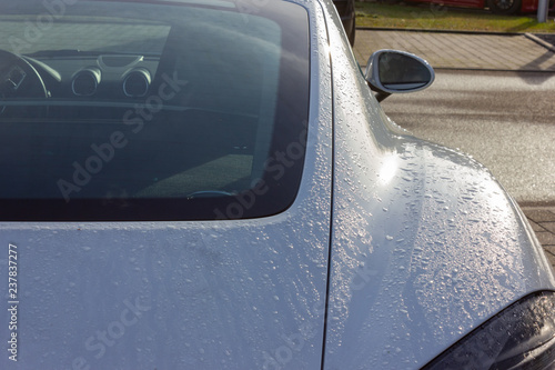 details of german sportscar body work with raindrops