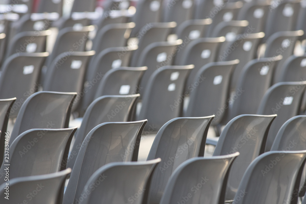 Fototapeta premium Rows of empty dark chairs. Abstract. Back view