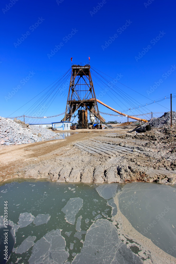 Drilling derrick and sewage pool in MaCheng iron mine, China