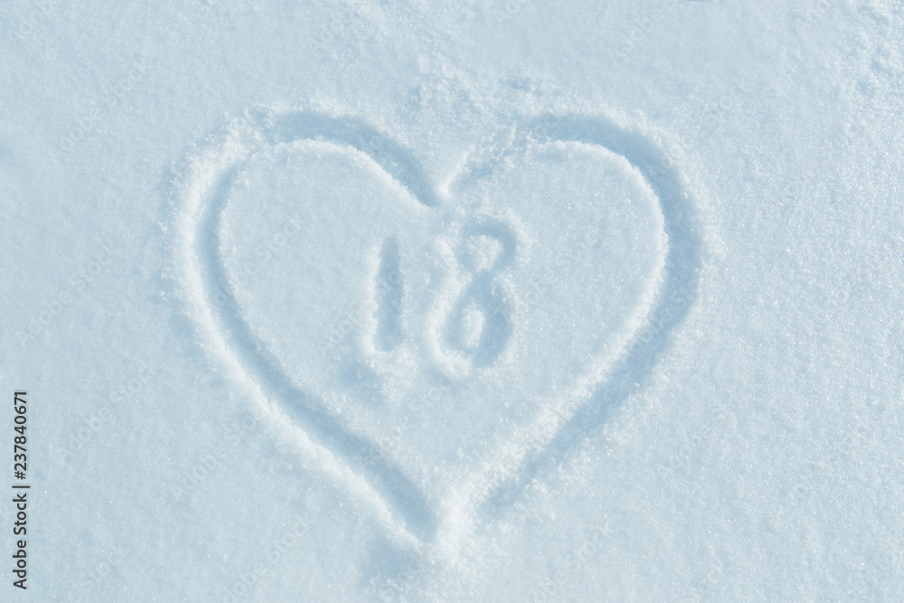 A figure of eighteen written in the snow in the painted heart. Snow texture. A figure of eighteen written in the snow in the painted heart. Snow texture.