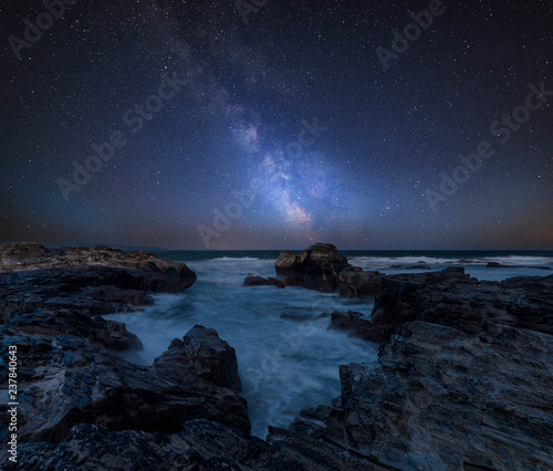 Vibrant Milky Way composite image over landscape of Cornwall coastline in England