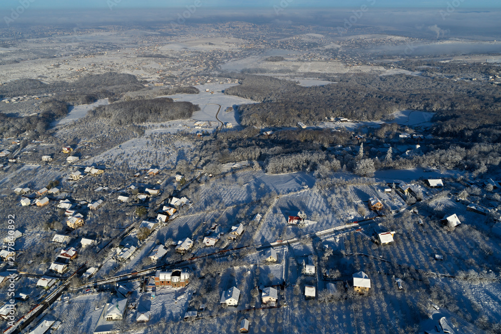 drone aerial view with houses and road in winter season