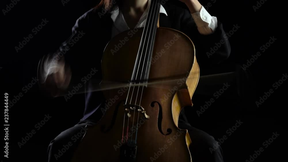 Cellist playing a musical composition .Black background Cellist playing a musical composition .Black background