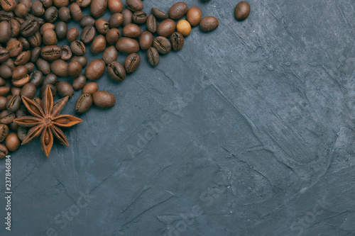 roasted coffee beans scattering in the corner of the background. beans on a dark background. view from above. copy space.