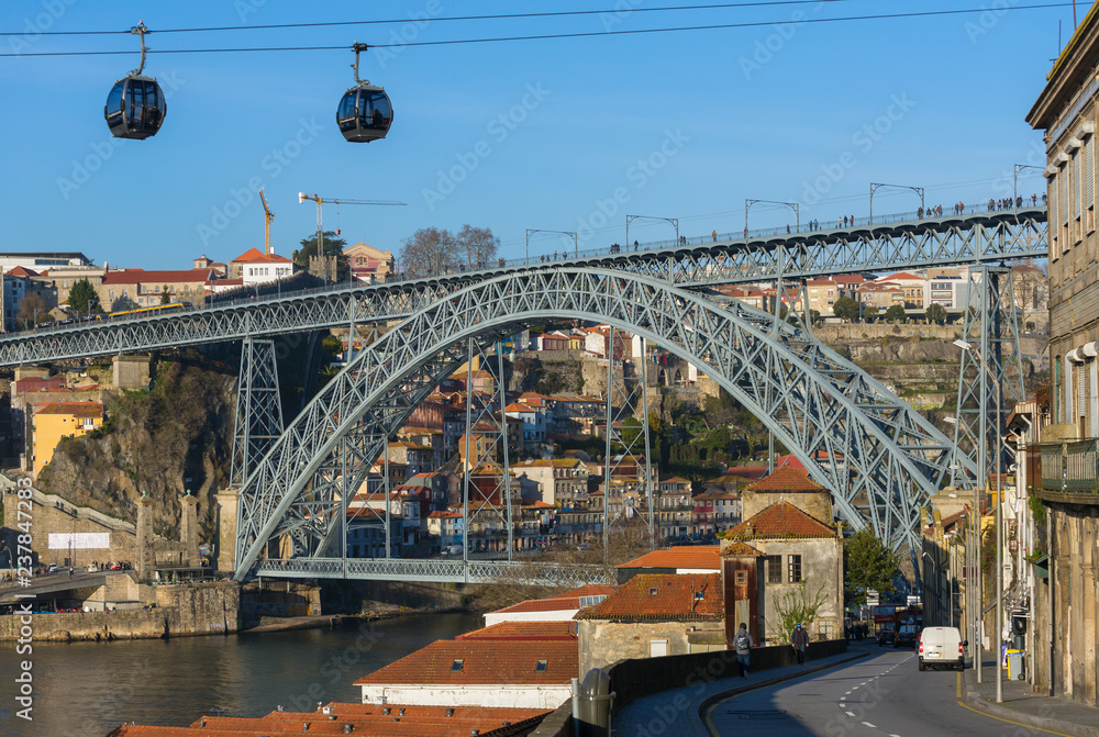 Fototapeta premium View of the famous bridge Ponte dom Luis and cable cars in Porto, Portugal
