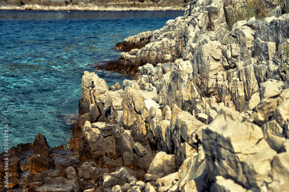 sharp rocks on the coast of Croatia. Dalmatia in the summer. Close up with shallow depth of field.