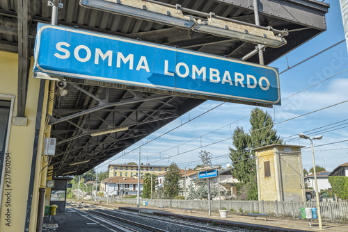 Somma Lombardo train station, town in the province of Varese, Lombardy, Italy, about 50 km (31 mi.) from Milan city. Focus on the foreground sign 