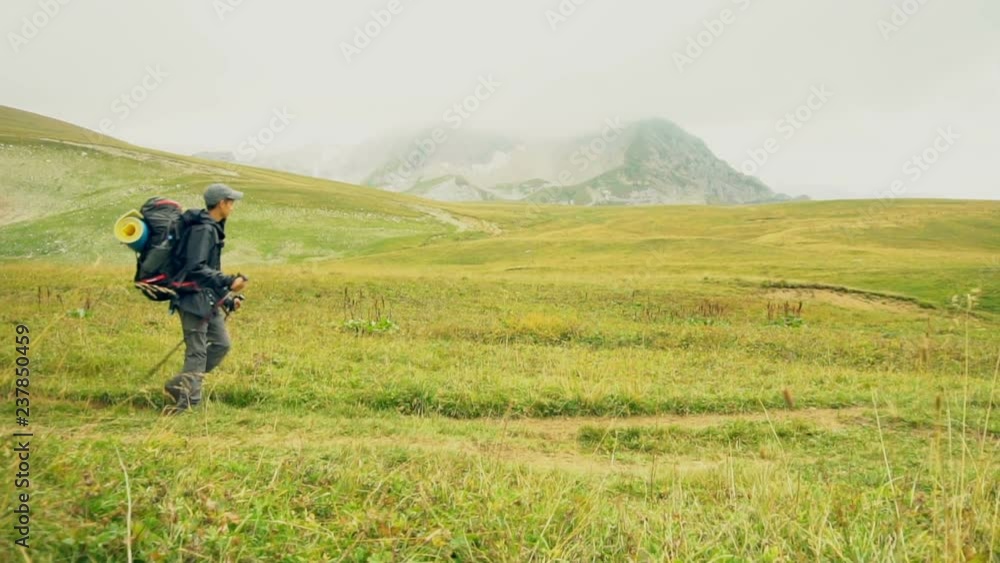 Little boy with backpack hiking in scenic green mountains. Slow motion 120 fps. Little boy with backpack hiking in scenic green mountains. Slow motion 120 fps.