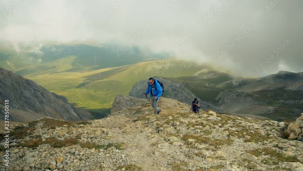 Hiker couple father and son in beautiful landscape. Hikers man and child trekking walking with backpacks in trail in mountains. Hiker couple father and son in beautiful landscape. Hikers man and child trekking walking with backpacks in trail in mountains.