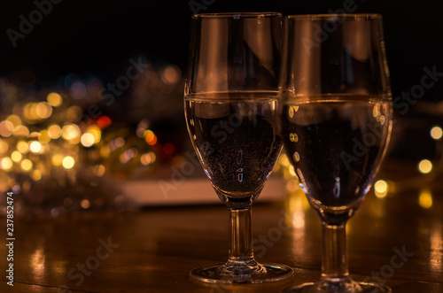  New Year. Glasses with champagne. New Year on the table are glasses of champagne and in the background is a beautiful bokeh. New year happy mood.