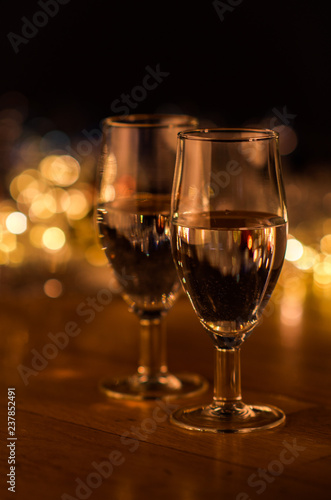  New Year. Glasses with champagne. New Year on the table are glasses of champagne and in the background is a beautiful bokeh. New year happy mood.