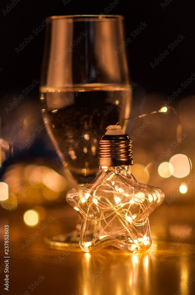  New Year. Glasses with champagne. New Year on the table are glasses of champagne and in the background is a beautiful bokeh. New year happy mood.